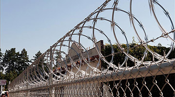 concertina razor wire atop chain link fence
